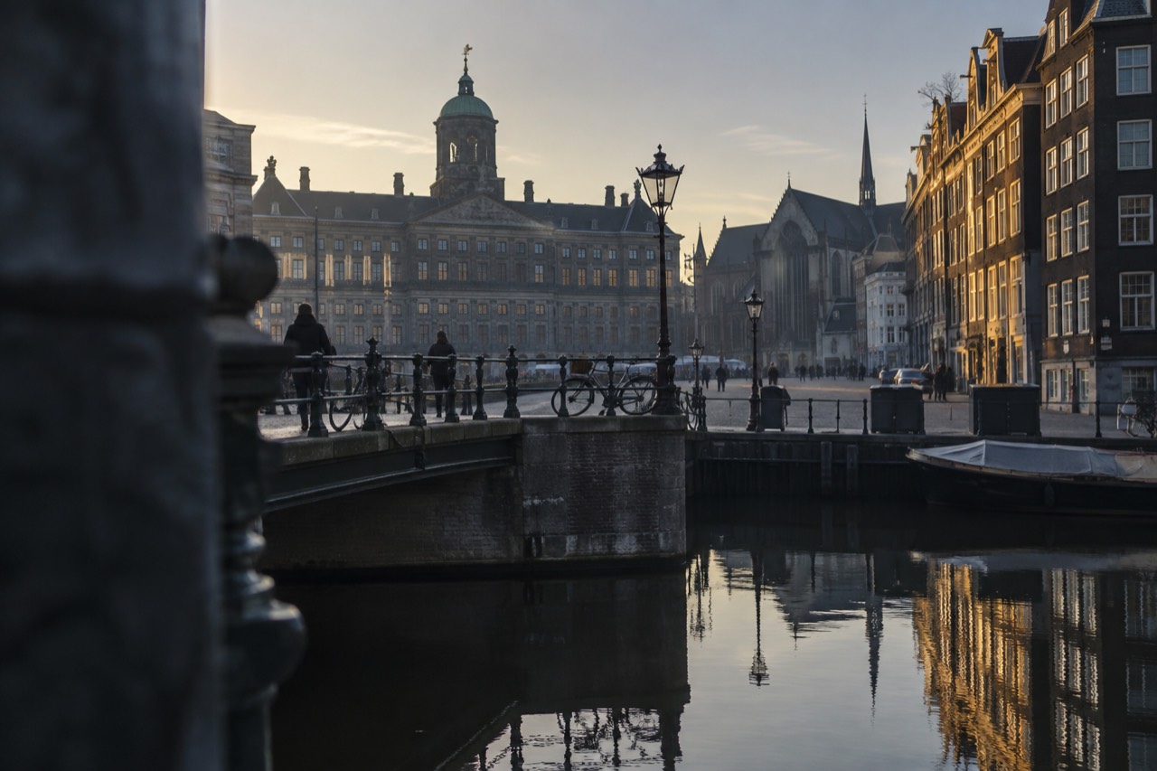 Amsterdam canal houses reflected in still water at dusk