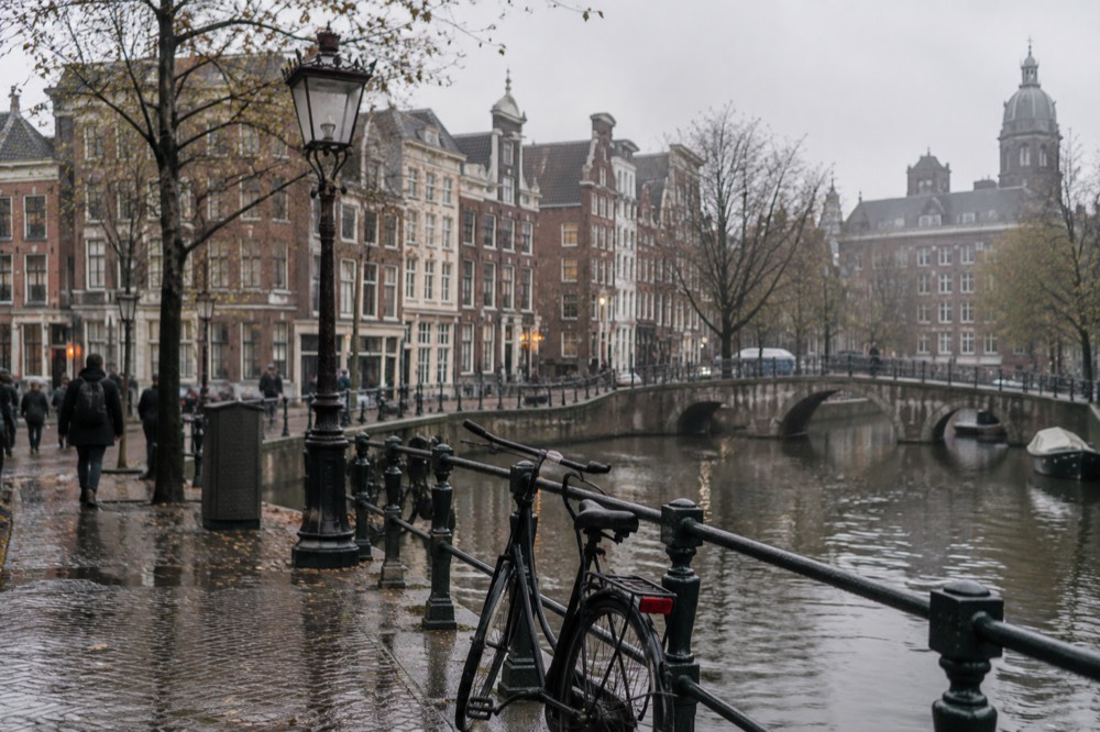 Brick facades and a quiet canal edge beside Dam Square
